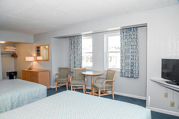 Two queen beds across from a table and chairs